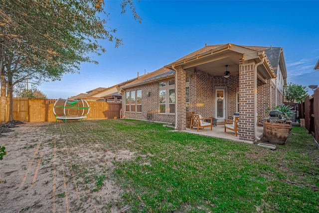 rear view of house with a patio, a yard, and ceiling fan