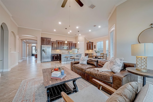 tiled living room with ceiling fan and ornamental molding