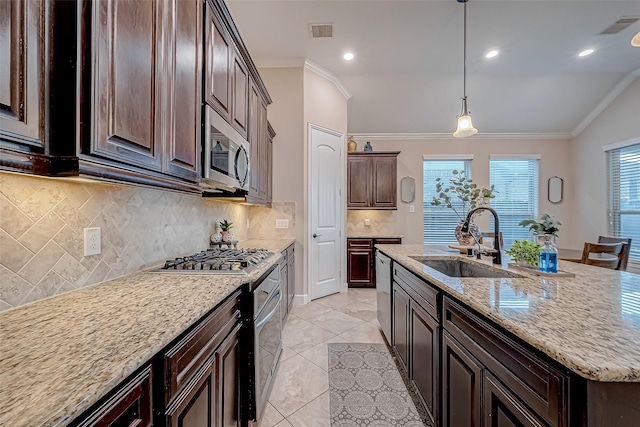 kitchen with crown molding, appliances with stainless steel finishes, sink, and a kitchen island with sink