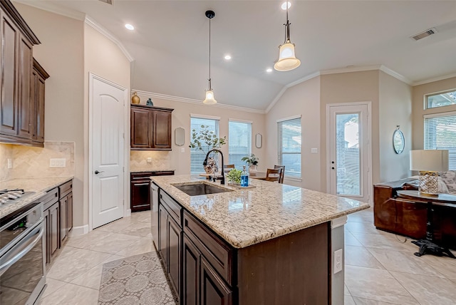 kitchen featuring sink, stainless steel oven, dark brown cabinets, a center island with sink, and pendant lighting