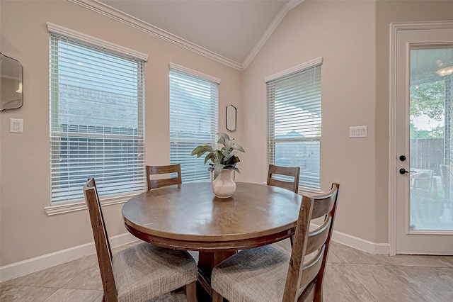 tiled dining space featuring ornamental molding and lofted ceiling