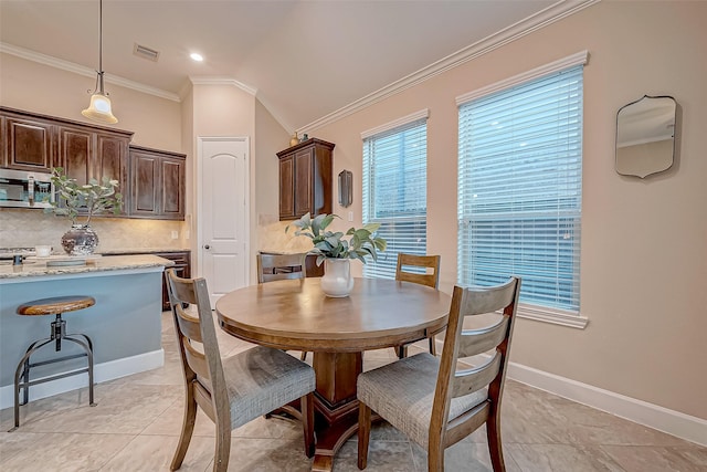 dining area with crown molding and vaulted ceiling