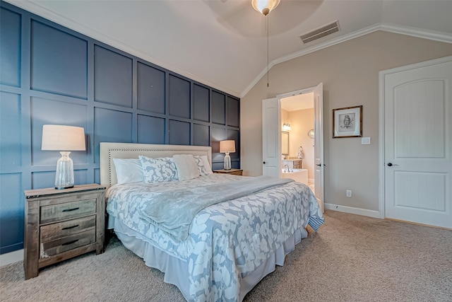 carpeted bedroom with ornamental molding, lofted ceiling, and ensuite bathroom