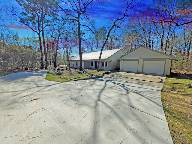 ranch-style home with a garage, concrete driveway, brick siding, and a front lawn