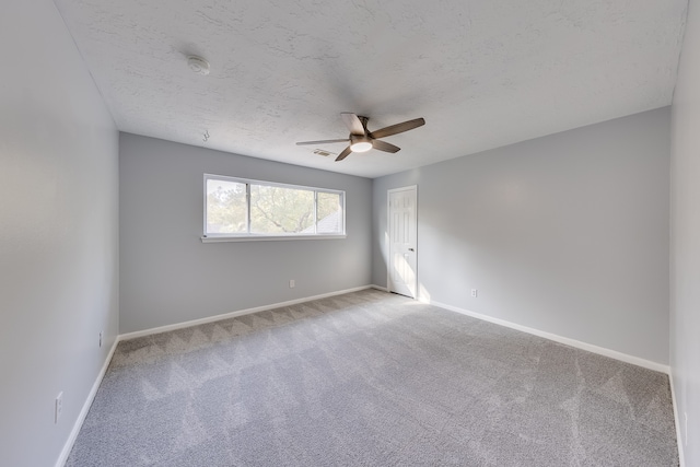 spare room with ceiling fan, carpet, and a textured ceiling