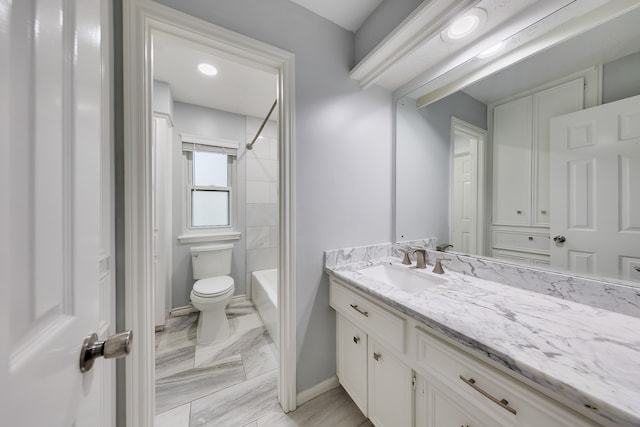 full bathroom featuring vanity, tiled shower / bath combo, and toilet