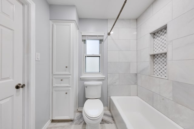 bathroom featuring toilet and tiled shower / bath