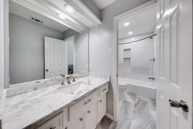 full bathroom featuring toilet, vanity, and tiled shower / bath combo