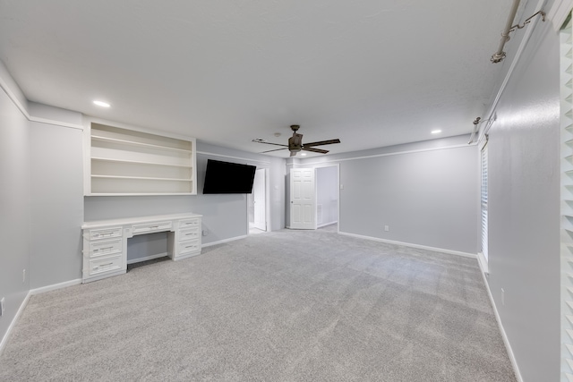 unfurnished living room featuring light colored carpet and ceiling fan