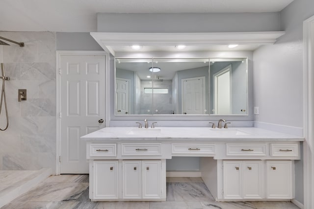 bathroom with a tile shower and vanity