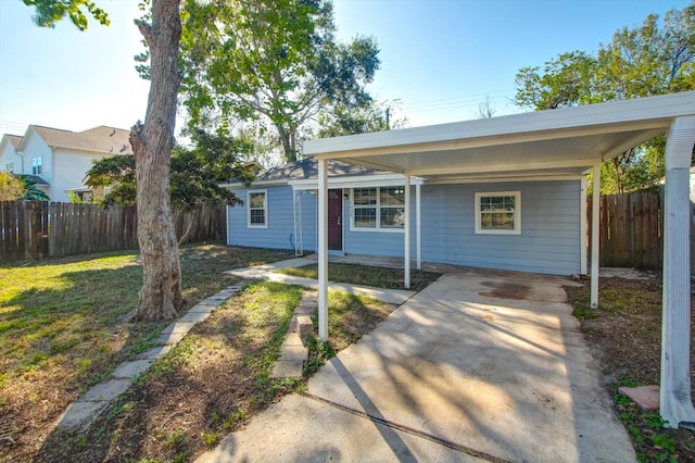 ranch-style house with a front yard and a carport