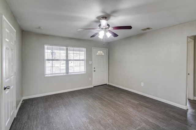 empty room with ceiling fan and dark wood-type flooring