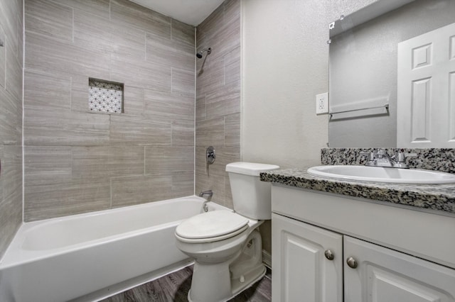 full bathroom with toilet, vanity, hardwood / wood-style flooring, and tiled shower / bath combo