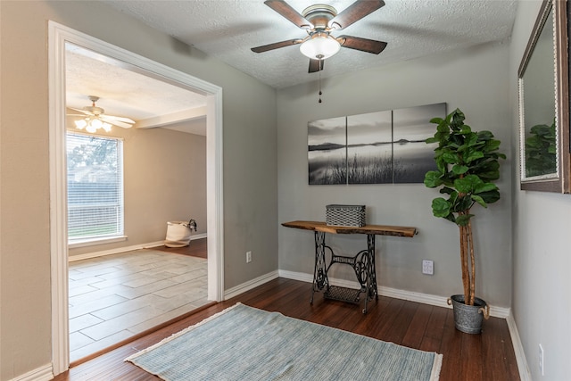 interior space with a textured ceiling, dark hardwood / wood-style floors, and ceiling fan