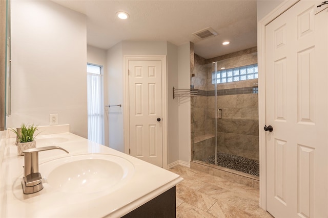 bathroom with vanity and a shower with door