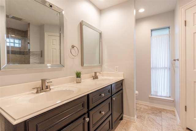 bathroom with plenty of natural light, vanity, and toilet