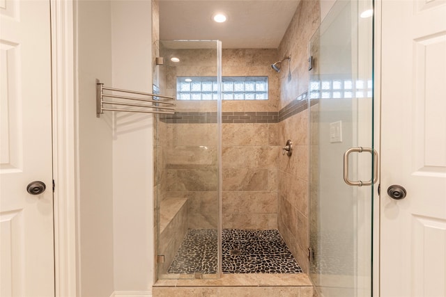 bathroom featuring a shower with door