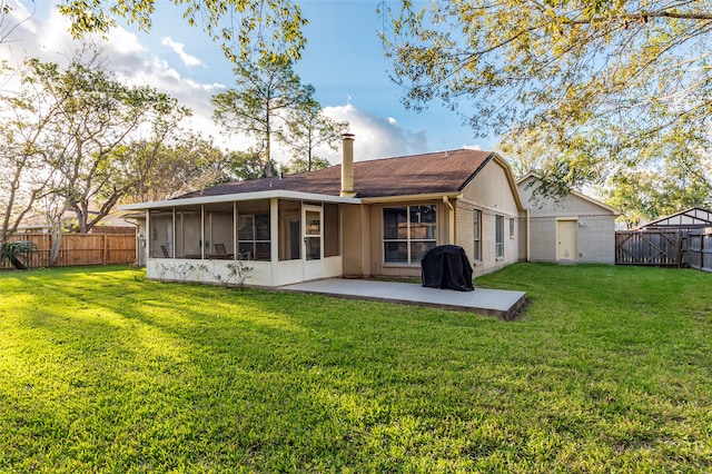 rear view of house featuring a patio, a sunroom, and a lawn