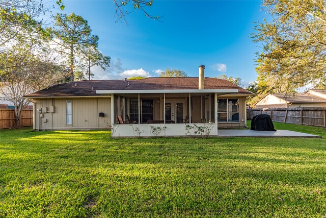 back of house featuring a patio, a sunroom, and a lawn