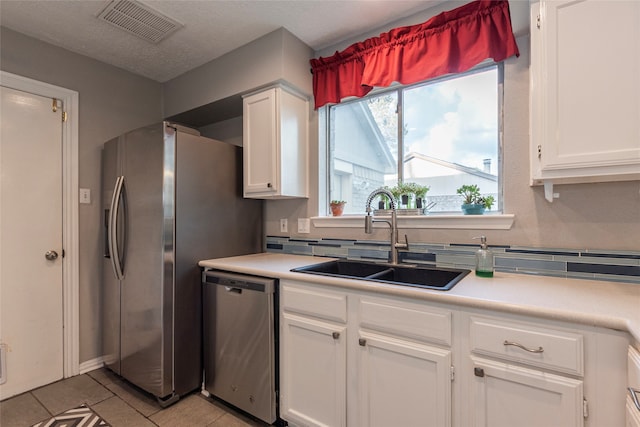 kitchen featuring white cabinets, light tile patterned floors, sink, and appliances with stainless steel finishes