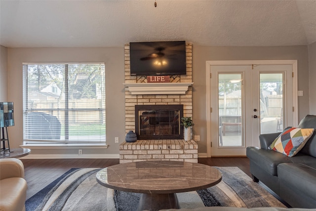 living room with french doors, a healthy amount of sunlight, and dark hardwood / wood-style floors