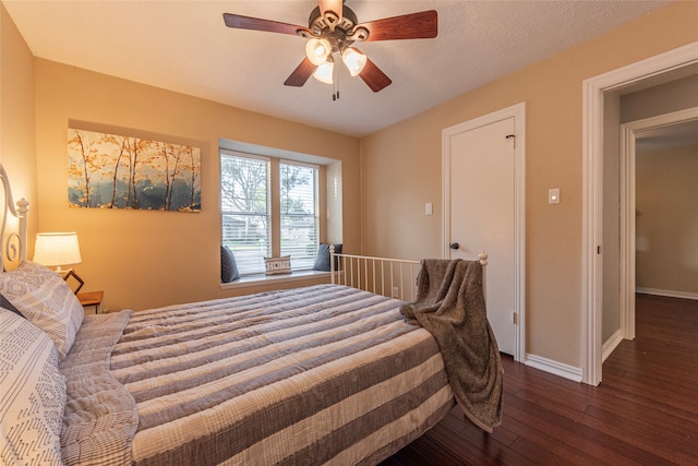 bedroom with dark hardwood / wood-style floors, ceiling fan, and a textured ceiling