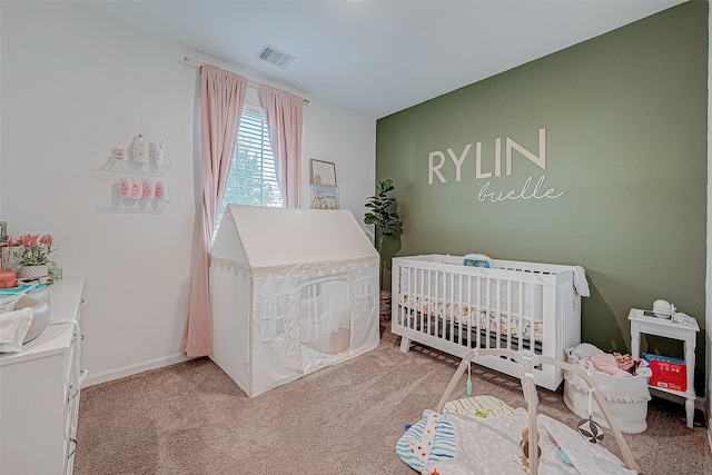 bedroom with light carpet and a nursery area