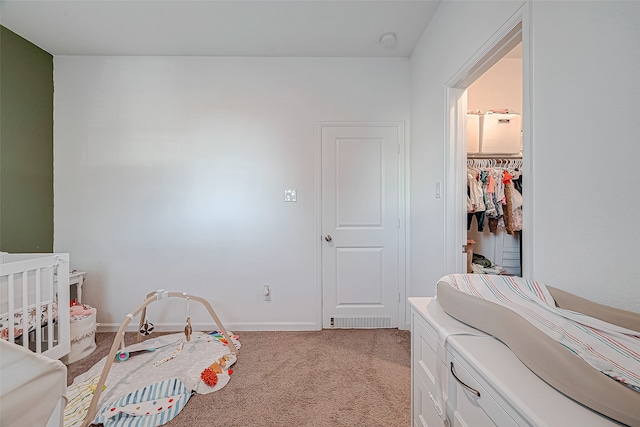 bedroom featuring light carpet, a spacious closet, and a closet