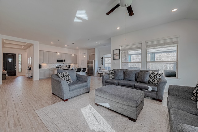 living room with ceiling fan and light hardwood / wood-style flooring