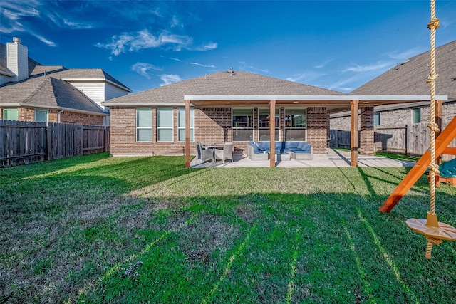 back of house with an outdoor living space, a patio area, and a lawn