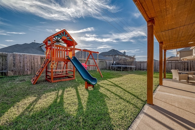 view of playground featuring a patio, a trampoline, and a lawn