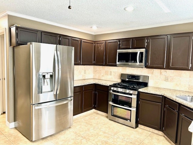 kitchen featuring appliances with stainless steel finishes, backsplash, dark brown cabinetry, and ornamental molding