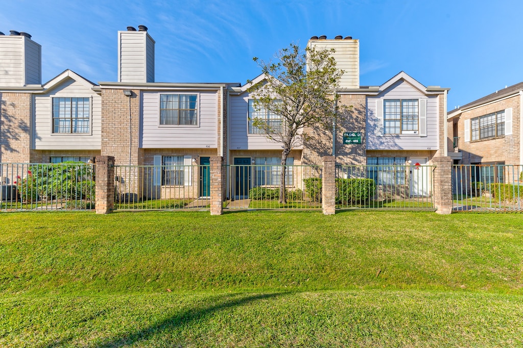 rear view of property featuring a lawn