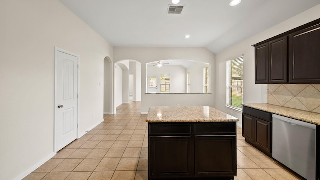 kitchen featuring tasteful backsplash, dark brown cabinetry, ceiling fan, dishwasher, and a center island