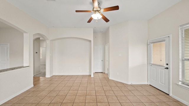 tiled spare room with ceiling fan