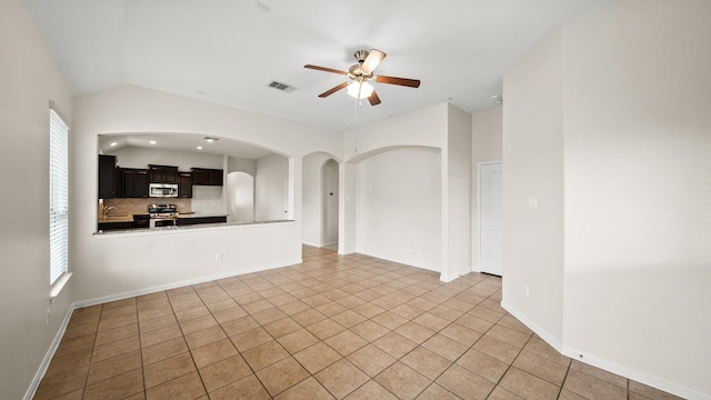 unfurnished living room featuring ceiling fan, lofted ceiling, and light tile patterned flooring