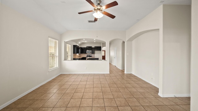 unfurnished living room with ceiling fan, light tile patterned floors, and lofted ceiling