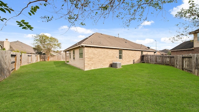 rear view of property with a lawn and cooling unit