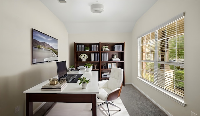 office with plenty of natural light, light colored carpet, and vaulted ceiling