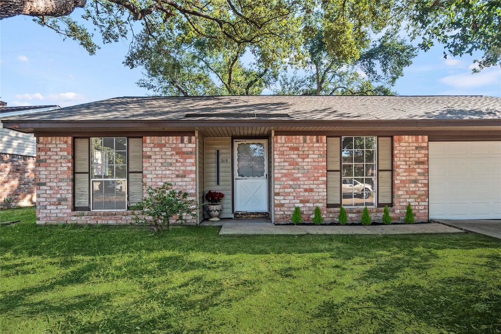 ranch-style home with a front lawn and a garage