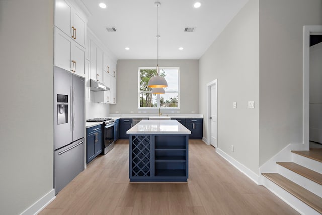 kitchen featuring stainless steel appliances, blue cabinets, pendant lighting, white cabinets, and a center island