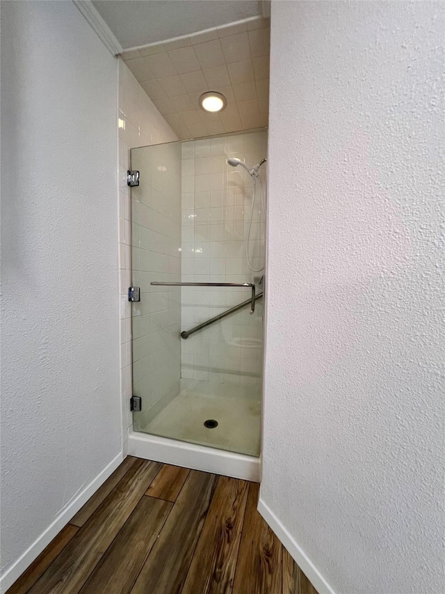 bathroom with hardwood / wood-style floors and tiled shower