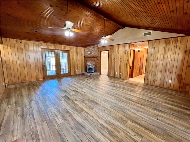 unfurnished living room with hardwood / wood-style flooring, lofted ceiling with beams, wood walls, and wooden ceiling