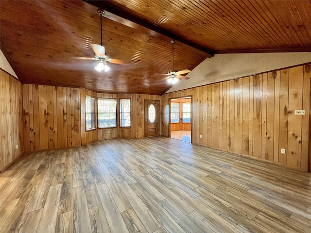 additional living space featuring light hardwood / wood-style flooring and wooden walls