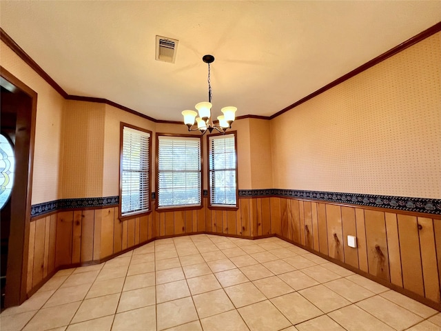 unfurnished dining area featuring ornamental molding, light tile patterned floors, and an inviting chandelier