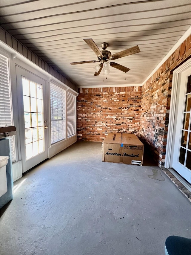 unfurnished sunroom with ceiling fan