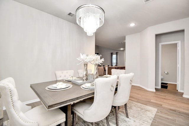 dining area featuring a chandelier and light hardwood / wood-style flooring