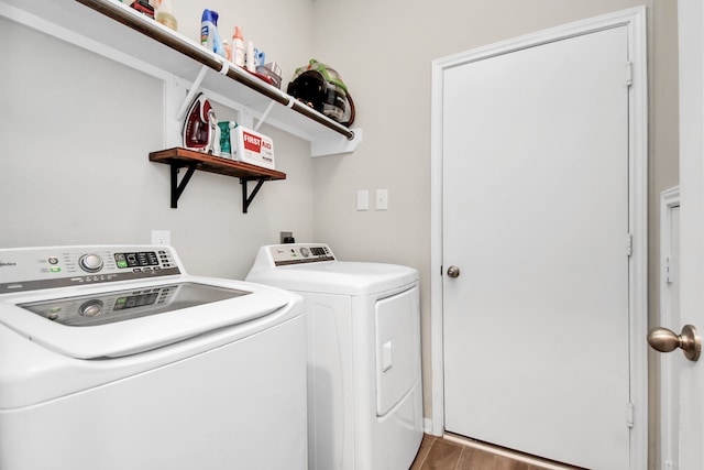 laundry room with separate washer and dryer and hardwood / wood-style flooring