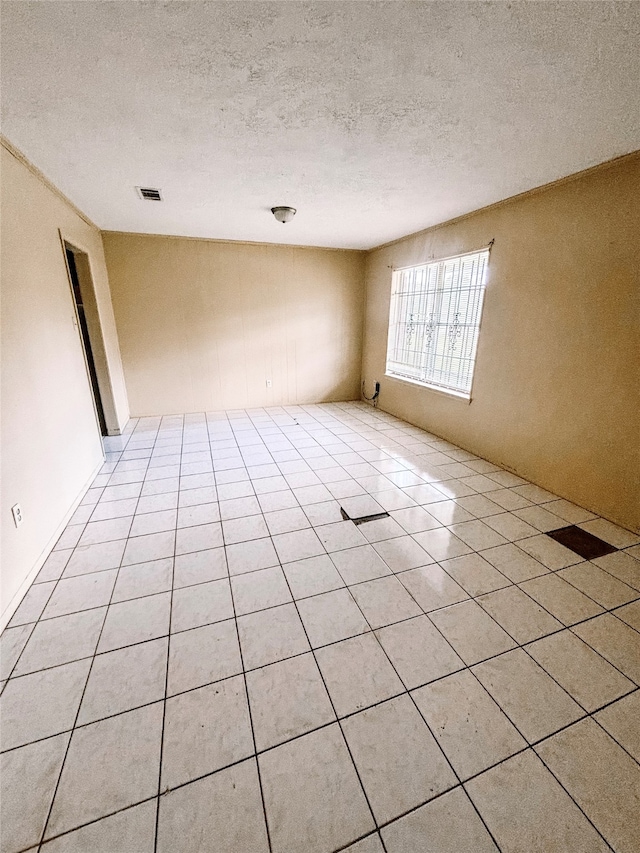 tiled spare room with a textured ceiling