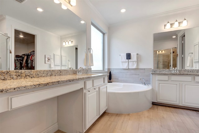 bathroom featuring crown molding, hardwood / wood-style floors, vanity, and shower with separate bathtub